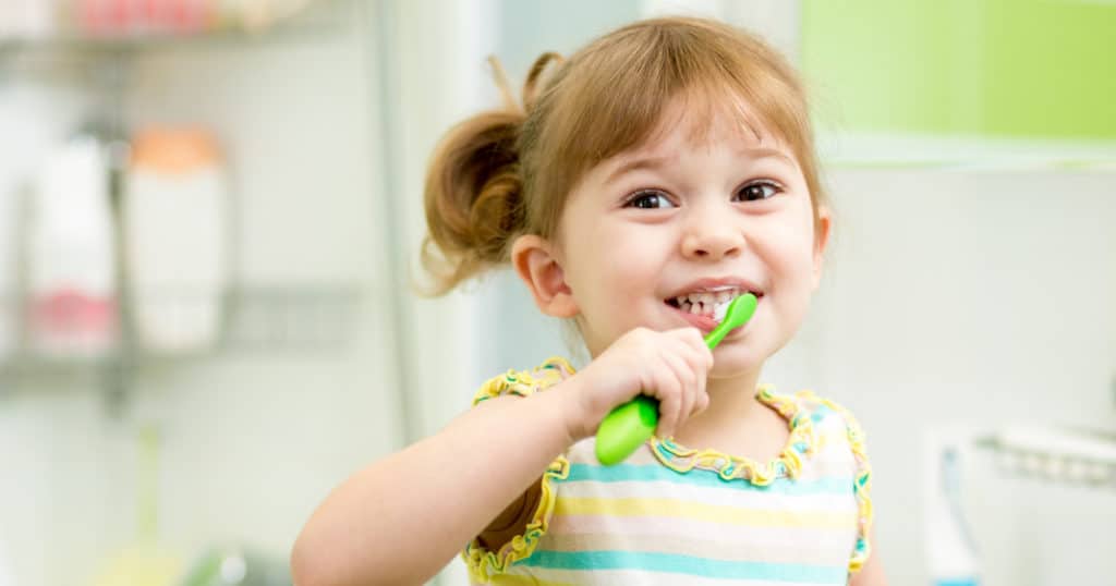 Pediatric dentistry patient brushing her teeth